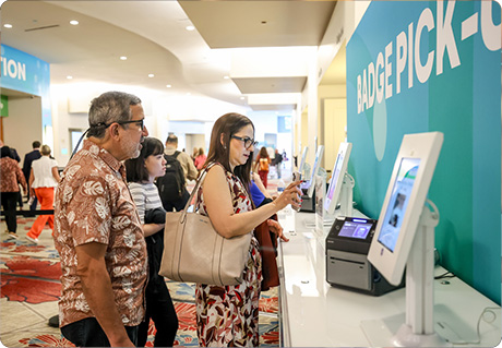 Attendees registering at kiosk